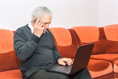 Senior Businessman Talking On Cell Phone And Typing On Laptop Sitting On Sofa. Royalty Free Stock Photo Senior Businessman Talking On Cell Phone And Typing On Laptop Sitting On Sofa. Royalty Free Stock Photo