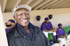 Senior Coach Smiling With Players In Background Royalty Free Stock Image Senior Coach Smiling With Players In Background Royalty Free Stock Image