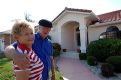 Senior couple in front of home