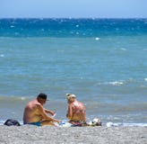 Senior Couple In Swimwear, Playing Cards On The Beach. Royalty Free Stock Images Senior Couple In Swimwear, Playing Cards On The Beach. Royalty Free Stock Images