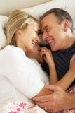 Senior Couple Relaxing Together In Bed Stock Photo Senior Couple Relaxing Together In Bed Stock Photo