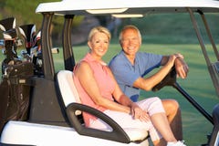 Senior Couple Riding In Golf Buggy