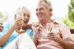 Senior Couple Sitting On Outdoor Seat Together Drinking Wine stock image Senior Couple Sitting On Outdoor Seat Together Drinking Wine stock image