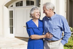 Senior couple standing outside house
