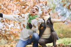 Senior couple throwing leaves in the air
