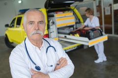 Senior doctor next to ambulance stock photos Senior doctor next to ambulance stock photos