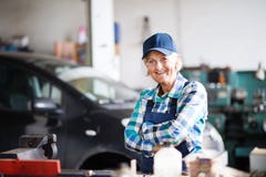 Senior female mechanic repairing a car in a garage. Stock Image Senior female mechanic repairing a car in a garage. Stock Image