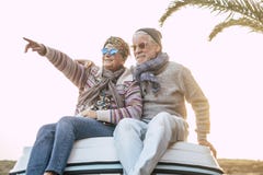 Senior Happy And Youhtful Couple Enjoy Together The Travel And Joy Lifestyle Sitting On The Roof Of A Van Vehicle - Love Forever Royalty Free Stock Photography