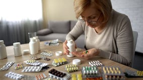 Senior lady taking too much pills, feeling unwell, heart problem self-medication royalty free stock photo Senior lady taking too much pills, feeling unwell, heart problem self-medication royalty free stock photo