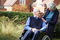 Senior Man Being Pushed In Wheelchair By Wife royalty free stock photo Senior Man Being Pushed In Wheelchair By Wife royalty free stock photo