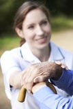 Senior Man's Hands Resting On Walking Stick With Care Worker In stock photos Senior Man's Hands Resting On Walking Stick With Care Worker In stock photos