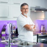 Senior man standing in his kitchen. Senior man standing in his renovated, modern kitchen Royalty Free Stock Photo Senior man standing in his kitchen. Senior man standing in his renovated, modern kitchen Royalty Free Stock Photo