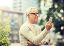 Senior man texting message on smartphone in city stock images Senior man texting message on smartphone in city stock images