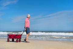 Senior man walking with cart at the beach royalty free stock photography Senior man walking with cart at the beach royalty free stock photography