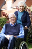 Senior Man In Wheelchair Being Pushed By Wife stock images Senior Man In Wheelchair Being Pushed By Wife stock images