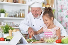 Man preparing dinner with granddaughter Royalty Free Stock Photo Man preparing dinner with granddaughter Royalty Free Stock Photo