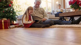 Senior man with granddaughter using digital tablet at home royalty free stock images Senior man with granddaughter using digital tablet at home royalty free stock images