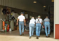 Senior Men Pushing Stalled Car into Garage