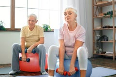 Senior couple exercise together at home doing aerobics with dubbells down royalty free stock photography Senior couple exercise together at home doing aerobics with dubbells down royalty free stock photography