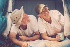 Senior Old Alternative Traveler Couple Inside A Tiny House Tent Enjoy The Travel And The Free Vacation With Camping Style - Royalty Free Stock Image