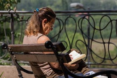 Senior woman on balcony sitting on bench and reading book stock photo Senior woman on balcony sitting on bench and reading book stock photo
