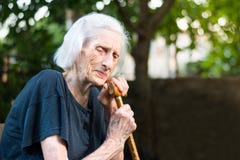 Senior woman crying with a walking cane stock image Senior woman crying with a walking cane stock image