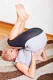 Senior woman doing yoga in living room stock photo Senior woman doing yoga in living room stock photo