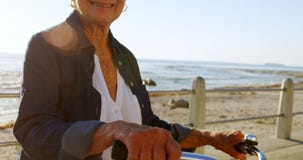 Senior woman holding bicycle at promenade 4k stock video footage Senior woman holding bicycle at promenade 4k stock video footage
