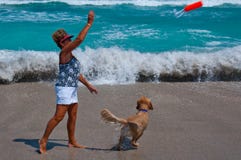 Senior Woman Playing With Dog On A Florida Beach. Stock Images Senior Woman Playing With Dog On A Florida Beach. Stock Images