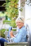 Senior woman reading book outdoors stock photography Senior woman reading book outdoors stock photography