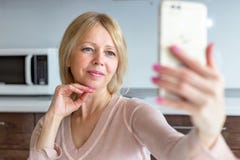 A senior woman taking a selfie at home stock images A senior woman taking a selfie at home stock images