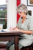 Senior woman writing notes at home royalty free stock photos Senior woman writing notes at home royalty free stock photos