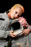 sensual female astronaut in spacesuit with peony flower and helmet