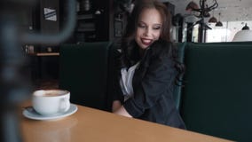 Sentada morena hermosa en un café, el ligar, mirando la cámara metrajes Sentada morena hermosa en un café, el ligar, mirando la cámara metrajes