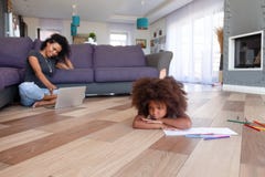 Sentimento afro-americano virado da menina furado quando mãe que usa o portátil fotos de stock Sentimento afro-americano virado da menina furado quando mãe que usa o portátil fotos de stock