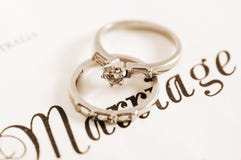 Sepia vintage retro style wedding and diamond engagement rings on marriage certificate