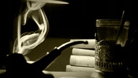 Sepiagesamtlänge eines ` s Büros 1930: Pfeife, Tee und ein Stapel Bücher Sepiagesamtlänge eines ` s Büros 1930: Pfeife, Tee und ein Stapel Bücher