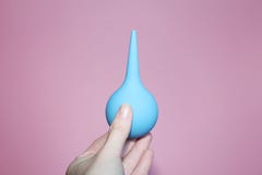 Seringue bleue avec une astuce molle dans une main femelle images stock Seringue bleue avec une astuce molle dans une main femelle images stock
