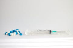 Seringue médicale avec une aiguille dans un paquet en plastique et quelques pilules photographie stock Seringue médicale avec une aiguille dans un paquet en plastique et quelques pilules photographie stock