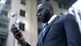 Serious afro-american businessman working on smartphone, business application royalty free stock photos Serious afro-american businessman working on smartphone, business application royalty free stock photos