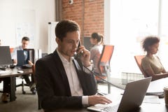 Serious businessman making call negotiating consulting customer looking at laptop stock image Serious businessman making call negotiating consulting customer looking at laptop stock image