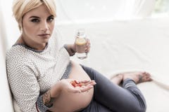 Serious expectant girl going to take medicine royalty free stock image Serious expectant girl going to take medicine royalty free stock image