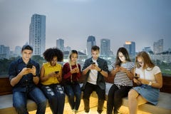 Serious group of young adults using smartphones in the cityscape stock photography Serious group of young adults using smartphones in the cityscape stock photography