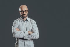 Serious middle aged man with a deadpan face expression dressed in casual posing on a dark gray background royalty free stock images Serious middle aged man with a deadpan face expression dressed in casual posing on a dark gray background royalty free stock images