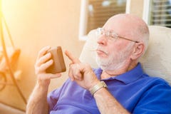Service de mini-messages adulte supérieur d'homme au téléphone portable intelligent image libre de droits Service de mini-messages adulte supérieur d'homme au téléphone portable intelligent image libre de droits