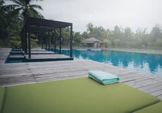 Serviette verte sur le lit du soleil près de la piscine photo libre de droits Serviette verte sur le lit du soleil près de la piscine photo libre de droits