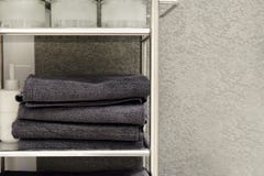 Serviettes, pantoufles de tapis et peignoirs pliés sur une étagère d'un cabinet dans un hôtel photos stock Serviettes, pantoufles de tapis et peignoirs pliés sur une étagère d'un cabinet dans un hôtel photos stock