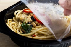 Servizio di distribuzione dell'alimento: Le mani della donna che giudicano aperte aderiscono involucro ed eliminano l'alimento in immagine stock libera da diritti Servizio di distribuzione dell'alimento: Le mani della donna che giudicano aperte aderiscono involucro ed eliminano l'alimento in immagine stock libera da diritti