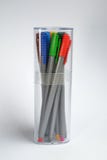 Set of multi-colored pens standing in closed transparent glass, side view on white background with shadow with copyspace royalty free stock photo Set of multi-colored pens standing in closed transparent glass, side view on white background with shadow with copyspace royalty free stock photo