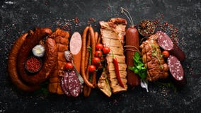 Set Of Sausage, Salami And Smoked Meat With Rosemary And Spices On A Black Stone Background. Top View. Stock Photography